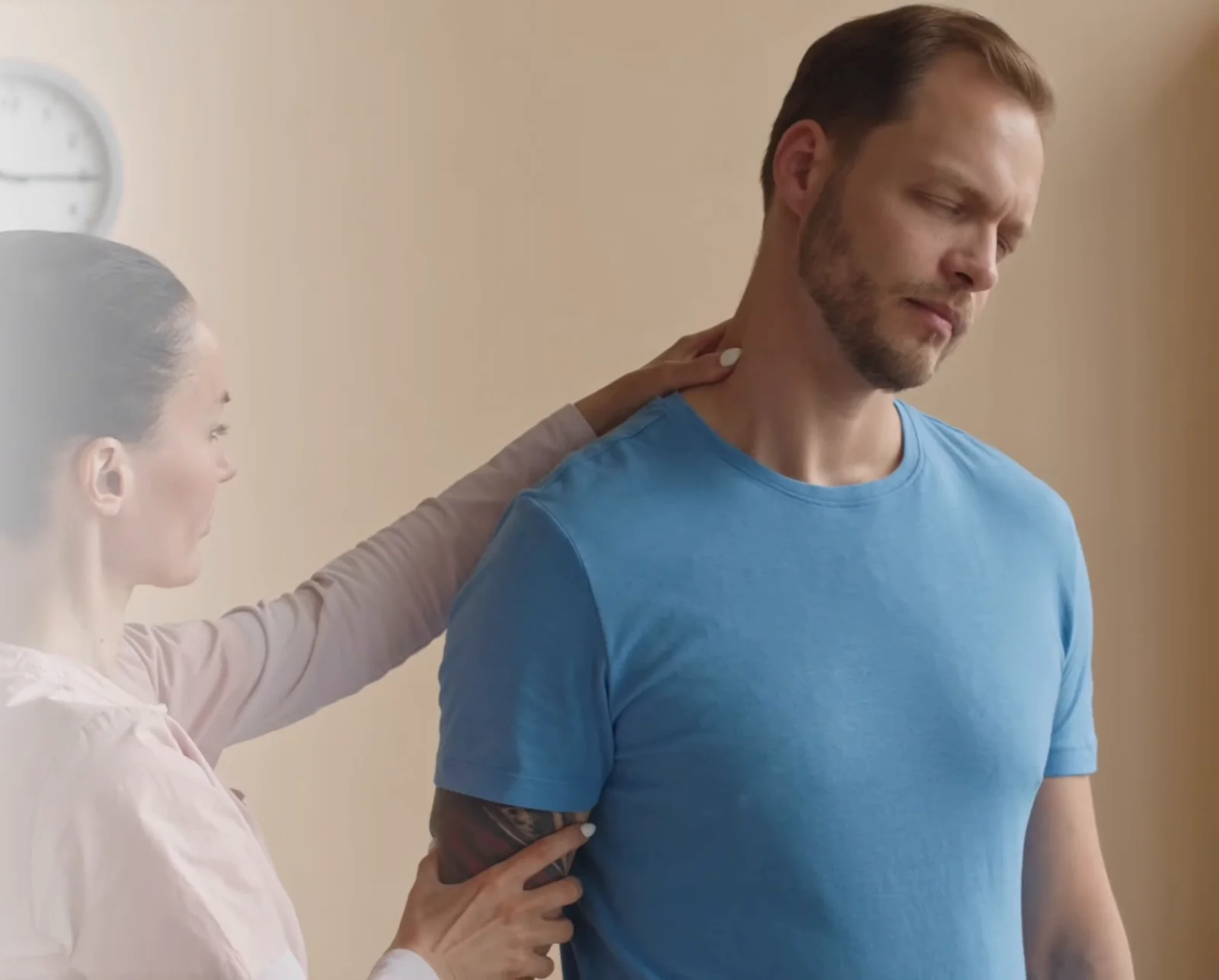 Practitioner assessing the shoulder and upper arm of a standing patient