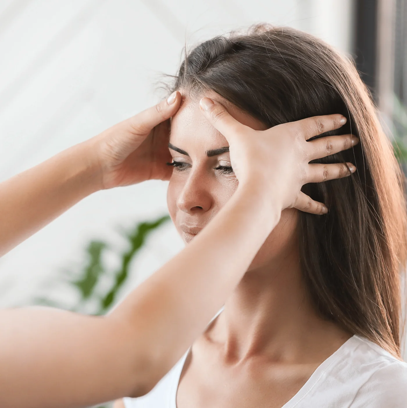 Woman pressing a hand to her forehead during a tension headache