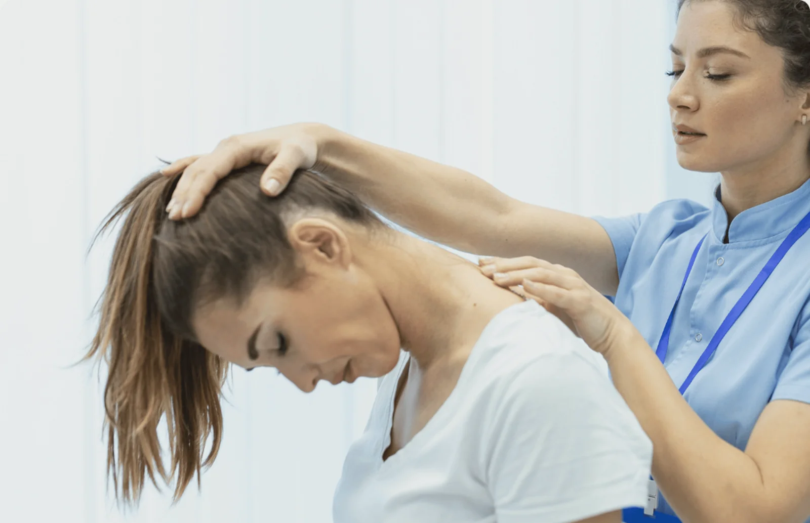Clinician guiding a seated patient through a gentle neck and shoulder mobilisation