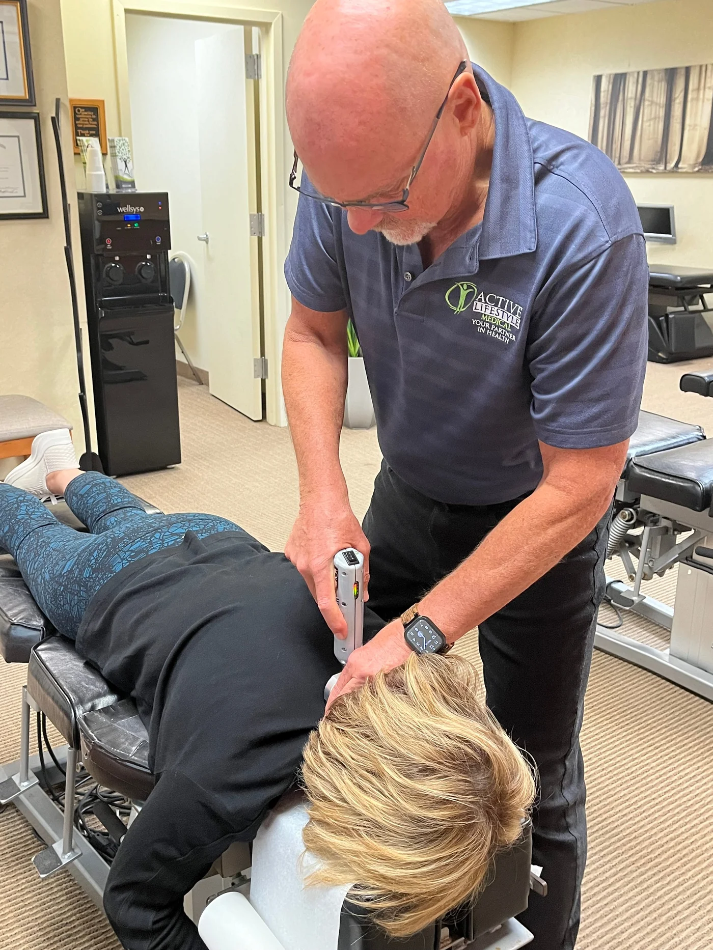 Close view of a hands-on adjustment being delivered to a patient resting face down on a padded table