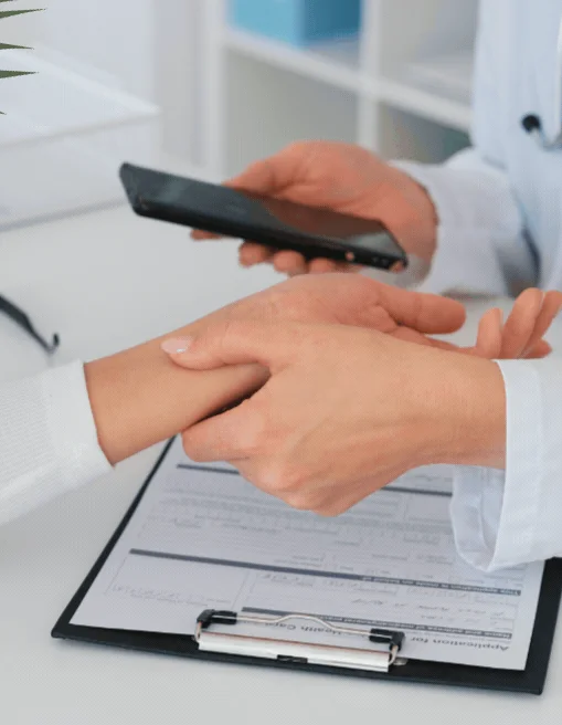 Clinician taking notes on a clipboard beside a patient during a consultation