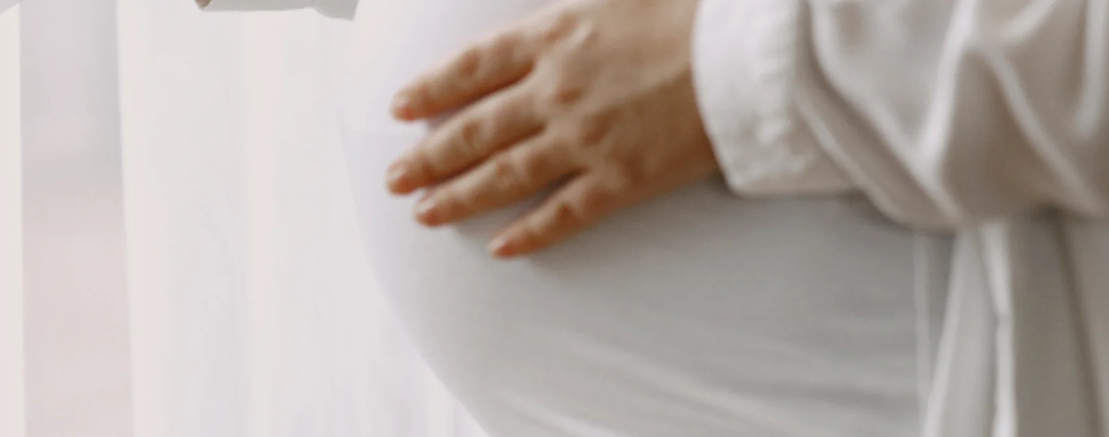 Expecting mother resting a hand on her pregnant belly