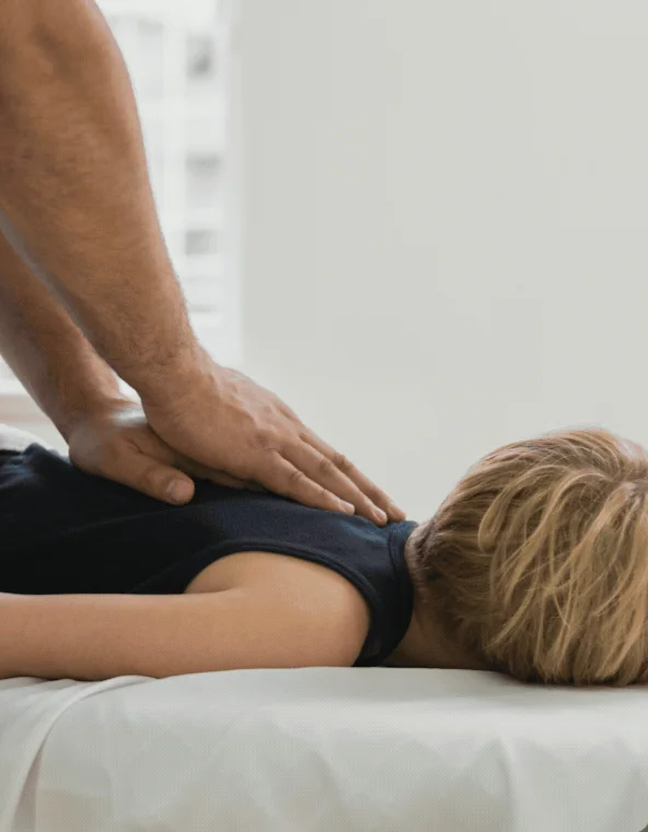 Practitioner applying steady pressure along the lower back of a patient lying face down