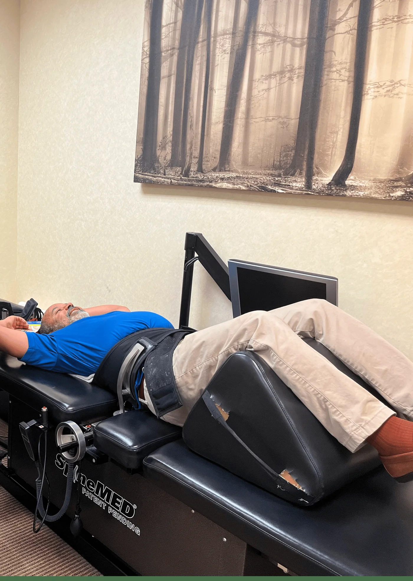 Patient lying on the SpineMED traction table with the pelvic harness fitted